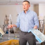 Portrait,Of,Confused,Man,Holding,Paint,Roller,And,Tray.,Repair
